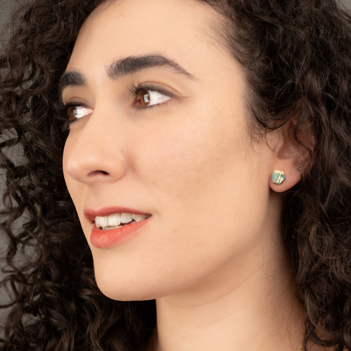 A photo of a woman wearing gold studs, blue and gold earrings, 14k plated gold studs, jewellery gifts for women