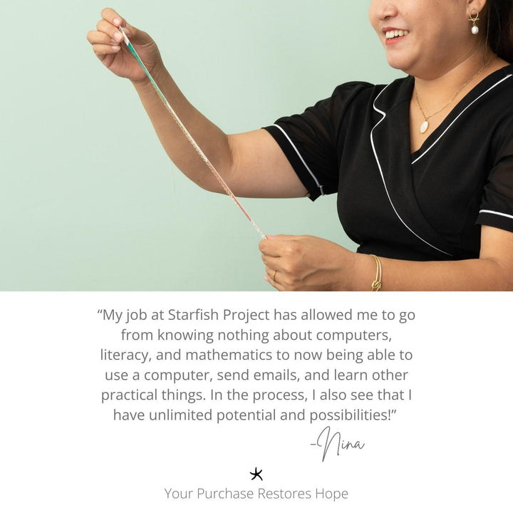 Woman smiling while wearing gold necklace with gold chain, a gold bracelet, and gold earrings with a pearl pendant, women's fair trade artisan jewellery, symbolism of hope, Starfish Project, jewellery website