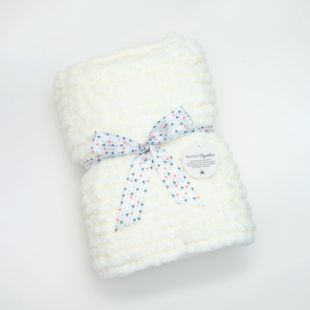 A white baby blanket gift wrapped, symbolism for hope, women's fair trade companies, starfish project reviews, Mother's day presents