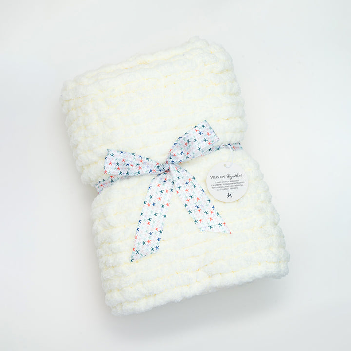 A white baby blanket gift wrapped, symbolism for hope, women's fair trade companies, starfish project reviews, Mother's day presents